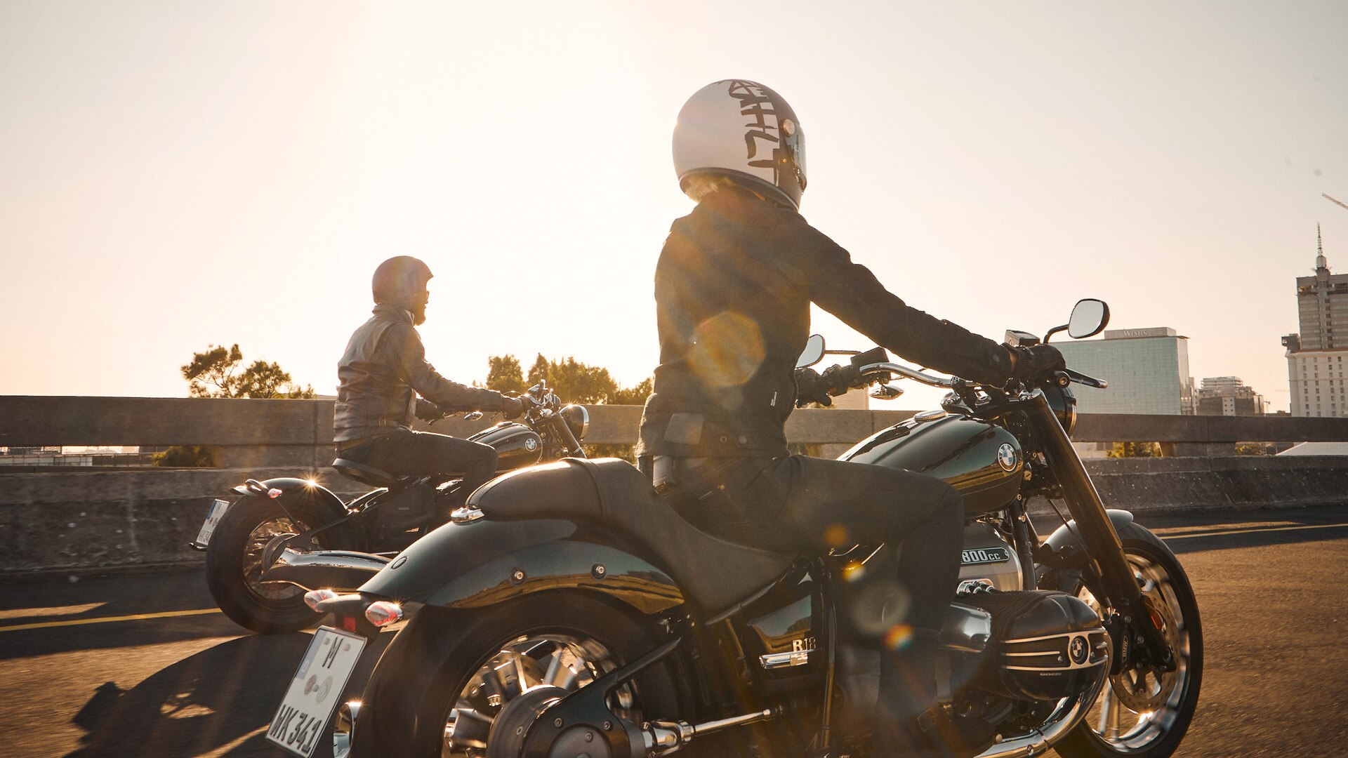 We zien twee motorrijders in het zonlicht.
