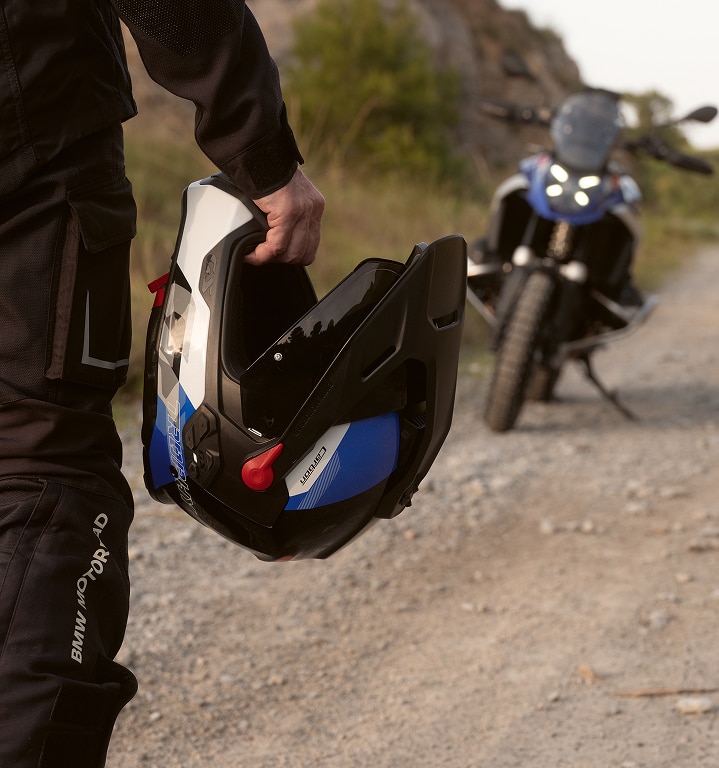 Een persoon houdt een motorhelm in zijn hand.